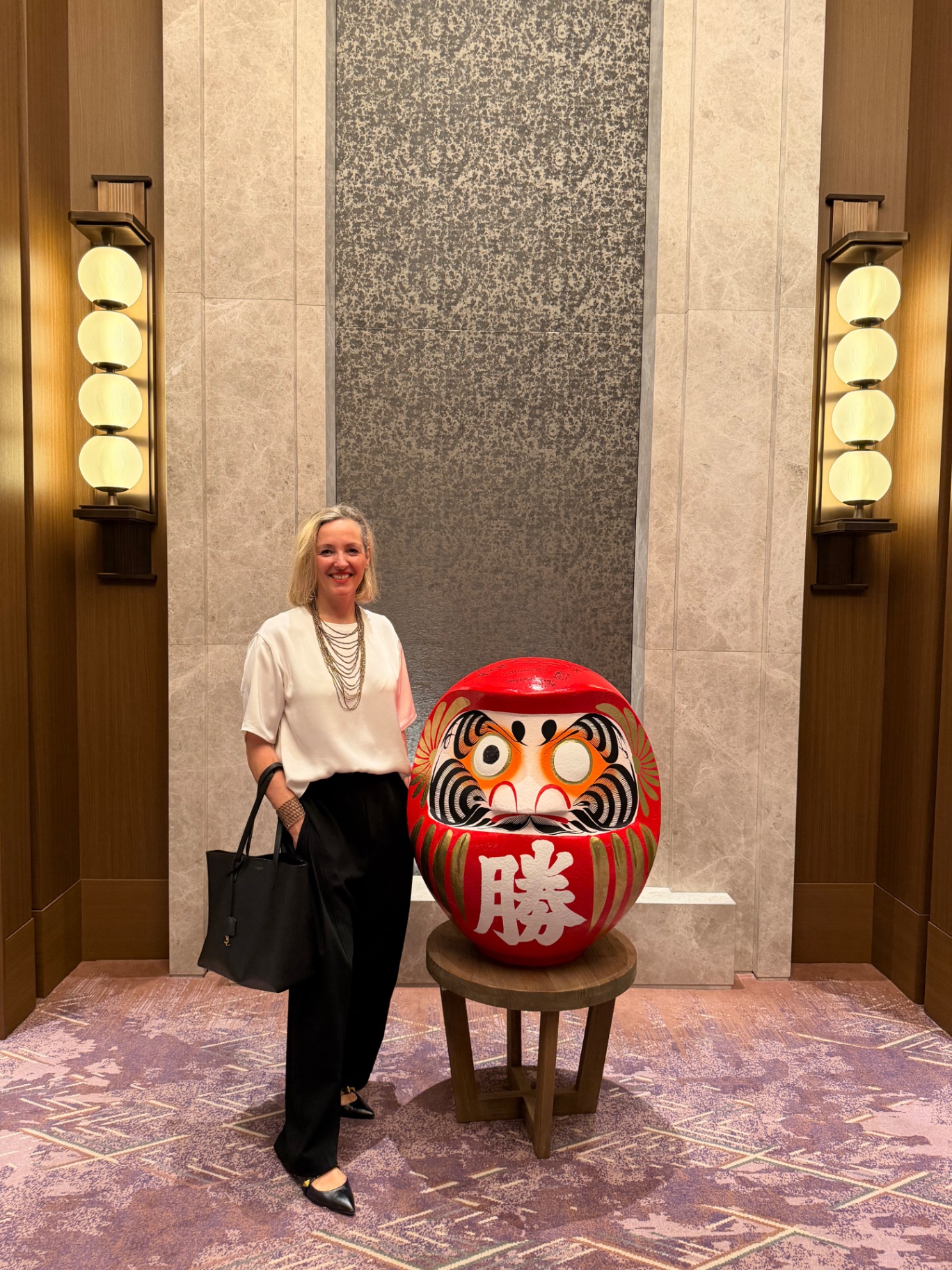 Nadine beside a red daruma in Osaka
